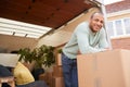 Portrait Of Man Unloading Furniture From Removal Truck Outside New Home On Moving Day Royalty Free Stock Photo