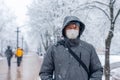 Portrait of a man wearing a medical protective mask on his face in winter, Covid-19 coronavirus pandemic, virus protection