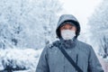 Portrait of a man wearing a medical protective mask on his face in winter, Covid-19 coronavirus pandemic, virus protection