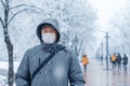 Portrait of a man wearing a medical protective mask on his face in winter, Covid-19 coronavirus pandemic, virus protection