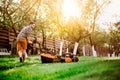 man wearing shirt cutting grass and using a lawn mower