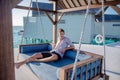 Portrait of man wearing shirt sitting on sofa near water villas at the tropical beach at island luxury resort Royalty Free Stock Photo