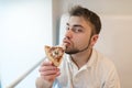 Portrait of a man who eats a piece of pizza and looks into the camera. A man with a beard enjoys the taste of hot pizza