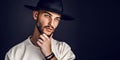 Portrait of a man in a wide-brimmed hat looking at camera on dark background. Royalty Free Stock Photo