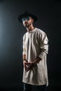 Portrait of a man in a wide-brimmed hat and sunglasses looking at camera on dark background. Royalty Free Stock Photo