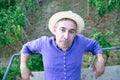 Portrait of man in straw hat sitting on bench on hill Royalty Free Stock Photo