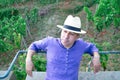 Portrait of man in straw hat sitting on bench on hill