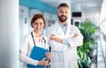 A portrait of man and woman doctor standing in hospital. Royalty Free Stock Photo