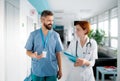 A portrait of man and woman doctor walking in hospital. Royalty Free Stock Photo