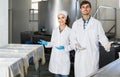 Portrait of man and woman dressed in lab coats are looking happy on the factory Royalty Free Stock Photo