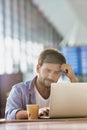 Portrait of man working with his laptop in cafe at airport while waiting for his flight Royalty Free Stock Photo