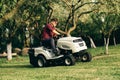 Portrait of man working with lawnmower and driving in garden Royalty Free Stock Photo