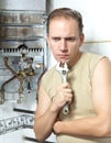 Portrait man with a wrench thinks of repair of a gas water heater Royalty Free Stock Photo