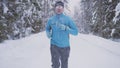 Portrait of a man 30 years old, running through the winter forest