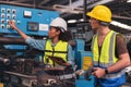 A portrait of a manufacturing worker in discussion with an industrial man and woman engineer holding a tablet in a factory. A Royalty Free Stock Photo