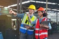 A portrait of a manufacturing worker in discussion with an industrial man and woman engineer holding a tablet in a factory. A Royalty Free Stock Photo