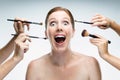 Many hands applying make-up to glamour woman over white background. Royalty Free Stock Photo