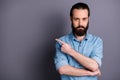 Portrait of masculine brutal bearded guy point index finger copy space indicate promo adverts present advertisements