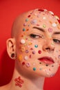 Masculine woman with rhinestones at her face and ear tunnels