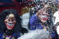 Portrait of masked person parading in the street throwing confetti