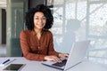 Portrait of mature adult successful businesswoman, african american woman at workplace smiling and looking at camera Royalty Free Stock Photo