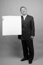 Portrait of mature Asian businessman against gray background Royalty Free Stock Photo