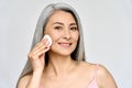 Portrait of mature Asian woman holding cotton pad doing everyday routine.