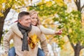 Portrait of mature attractive man giving his wife a piggy ride back in park Royalty Free Stock Photo