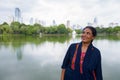 Mature beautiful Indian woman smiling and thinking in park Royalty Free Stock Photo