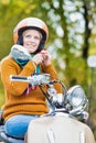 Portrait of mature beautiful woman putting her helmet on to ride motorbike in park Royalty Free Stock Photo