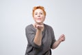 Portrait of mature beautiful woman with short red hairstyle in gray shirt sending an air kiss Royalty Free Stock Photo