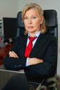 Portrait of mature boss woman in red tie at office