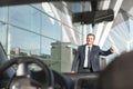 Portrait of mature businessman calling taxi in the airport