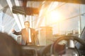 Portrait of mature businessman calling taxi in the airport with yellow lens flare Royalty Free Stock Photo