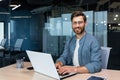 Portrait of mature businessman inside modern office, senior man in shirt smiling and looking at camera, worker using Royalty Free Stock Photo