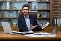 Portrait of mature businessman inside office at workplace, man with documents smiling and looking at camera, paperwork