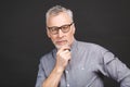 Portrait of a mature businessman wearing glasses  against black background. Happy senior man looking at camera with copy Royalty Free Stock Photo