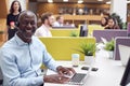 Portrait Of Mature Businessman Wearing Phone Headset Talking To Caller In Customer Services Centre Royalty Free Stock Photo