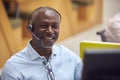 Portrait Of Mature Businessman Wearing Phone Headset Talking To Caller In Customer Services Centre Royalty Free Stock Photo