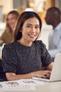 Portrait Of Mature Businesswoman In Wheelchair Sitting At Desk Working On Laptop In Busy Office Royalty Free Stock Photo