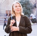 Portrait of mature cheerful woman standing on a old city street Royalty Free Stock Photo