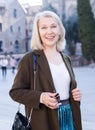 Portrait of mature cheerful woman standing on a old city street Royalty Free Stock Photo