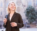 Portrait of mature cheerful woman standing on a old city street Royalty Free Stock Photo
