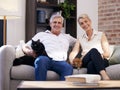 This is our idea of a cosy weekend in. Portrait of a mature couple relaxing with their pet cats on a sofa at home. Royalty Free Stock Photo