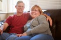 Portrait Of Mature Couple Sitting On Sofa At Home Royalty Free Stock Photo