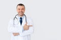 Portrait of mature doctor smiling and pointing at copy space Royalty Free Stock Photo