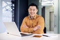 Portrait of mature experienced Asian businessman inside office at workplace, boss programmer sitting at desk with arms Royalty Free Stock Photo