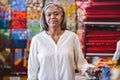 Mature woman standing in her colorful fabric store Royalty Free Stock Photo