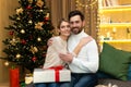 Portrait of mature family bearded man and blonde woman looking at camera hugging near Christmas tree, couple celebrating Royalty Free Stock Photo