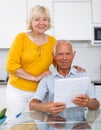 Portrait of mature family couple with bills at kitchen table Royalty Free Stock Photo